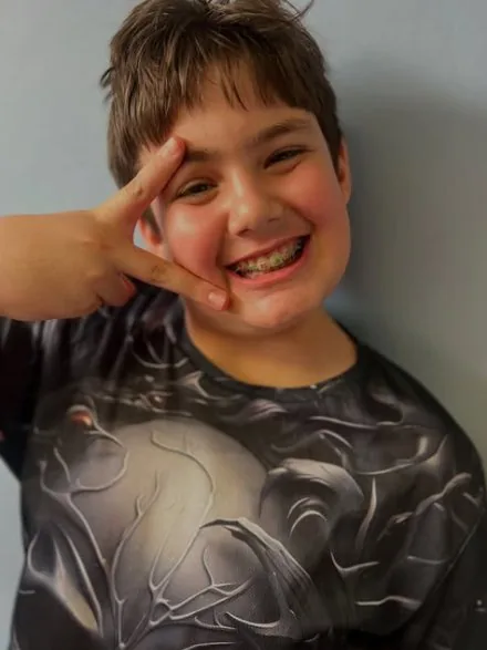 Tristan, a young SAVOY patient, smiling with his braces